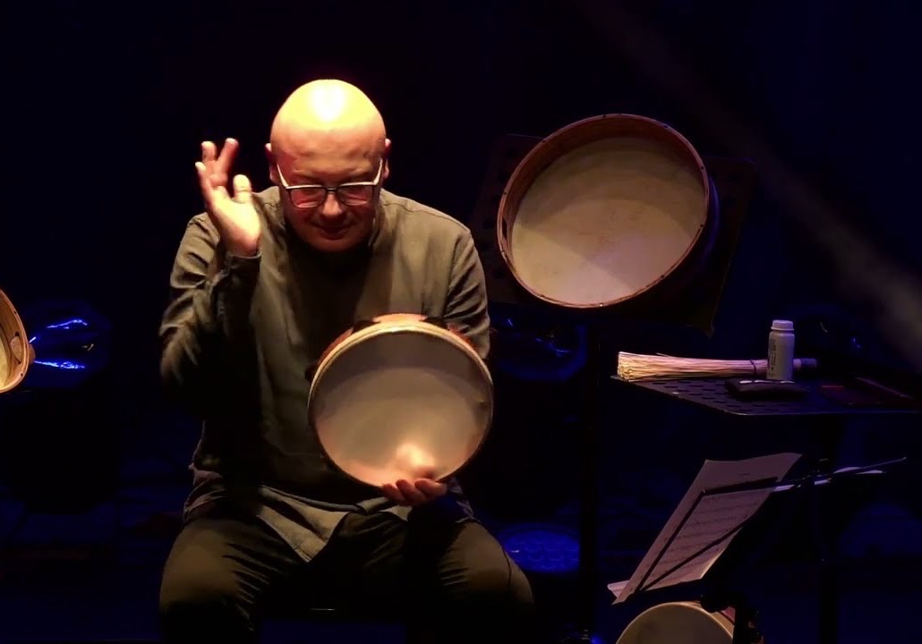 Andrea Piccioni sul palco con il tamburello, circondato dai tamburi a cornice